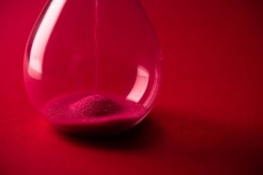 Arka planda kırmızı kum saatinin yakın çekimi. Zaman kavramı.