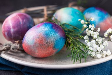 Tabakta klasik paskalya yumurtası, koyu taş zemin.