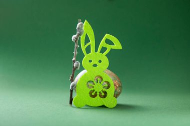 Yeşil arka planda tavşan oyuncağı ve paskalya yumurtaları olan en küçük paskalya konsepti.. 