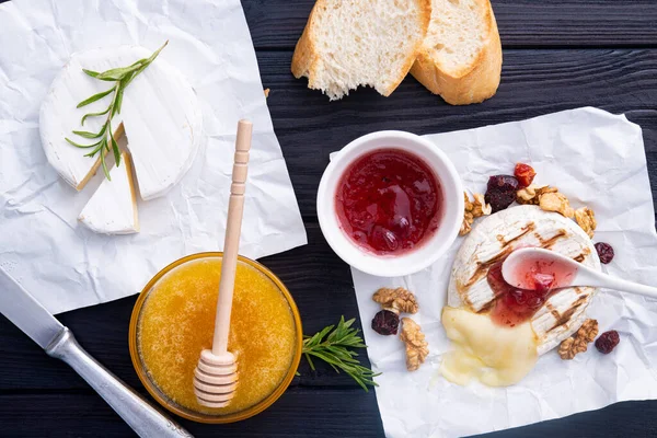 Koyu ahşap arka planda ızgara peynirli, üzümlü, fındıklı ve kızılcık reçelli lezzetli bir tatlı. en üstteki görünüm