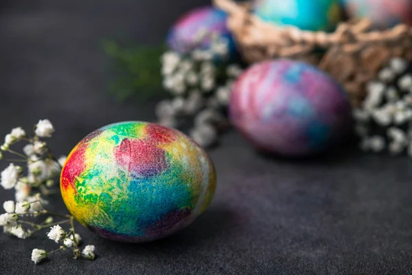 Easter holiday concept with colored space egg on a dark stone background