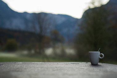 Dağlarda bir fincan sabah kahvesi, soğuk havada sıcak bir içecek.