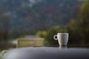 Dağlarda bir fincan sabah kahvesi, soğuk havada sıcak bir içecek.