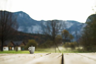 Dağlarda bir fincan sabah kahvesi, soğuk havada sıcak bir içecek.