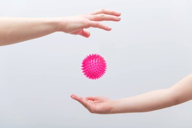 Kırmızı virüs modeli olan kadın ve çocuk eli. İnsanlar arasında koronavirüs bulaşması kavramı.