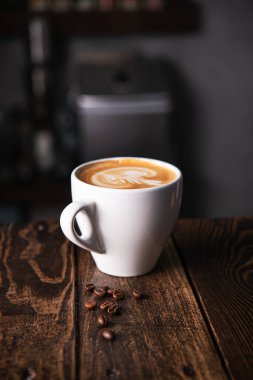 Kafe masasında beyaz bir fincan kahve