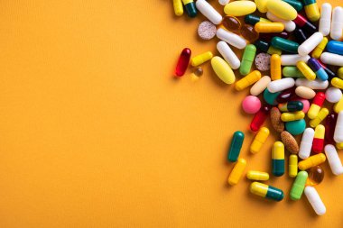 Sarı arka planda renkli vitamin ve haplar grubu. Üst Manzara. metin için kopyalama alanı