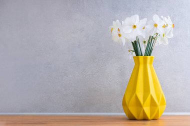 Sarı İskandinav vazosundaki güzel nergis çiçekleri.