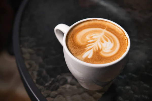 Filiżanka Wzorzystej Kawy Pianie Stoliku Kawiarni — Zdjęcie stockowe