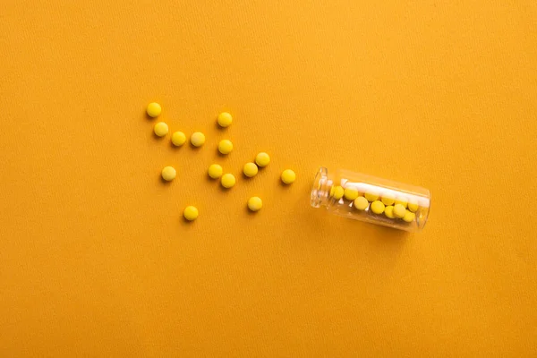 Closeup Small Pills Glass Bottle Yellow Background — Stock Photo, Image