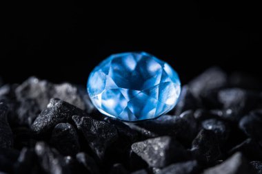 Taşların arasında büyük mavi bir elmas siyah arkaplan.