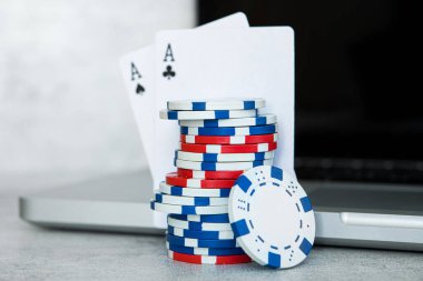 Online poker oyunları, gri arkaplanda dizüstü bilgisayarı olan çipler ve kartlar.
