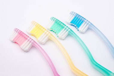 Beyaz arka planda dört kişilik bir aile için diş fırçası seti. Ağız temizliği kavramı.