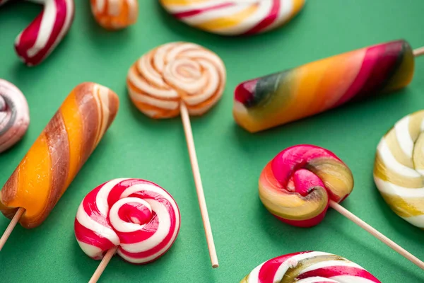 Smaklig Godis Lollypops Olika Färger Grön Bakgrund Begreppet Popkonst Utsikt — Stockfoto