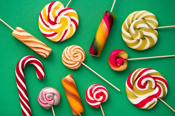 Smaczne Cukierki Lizaki Różnych Kolorach Zielonym Tle Koncepcja Pop Artu — Zdjęcie stockowe