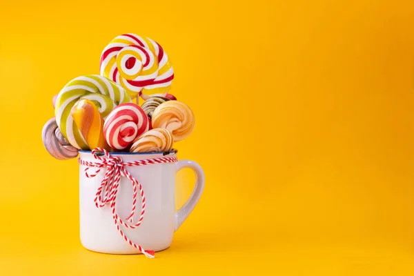 Minimal concept with cup and colored lollypops. Sweet trend popular food background.