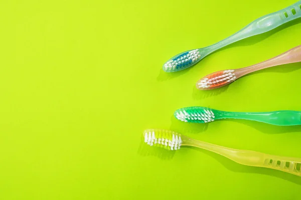 Nowe Kolorowe Szczoteczki Zębów Zielonym Tle Rodzinna Koncepcja Opieki Stomatologicznej — Zdjęcie stockowe