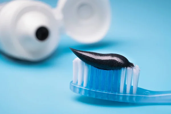 Schwarze Holzkohle Zahnpasta Auf Einer Zahnbürste Blauer Hintergrund — Stockfoto