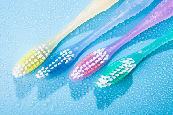 Farbige Zahnbürsten Mit Wassertropfen Badezimmer Blauer Hintergrund — Stockfoto