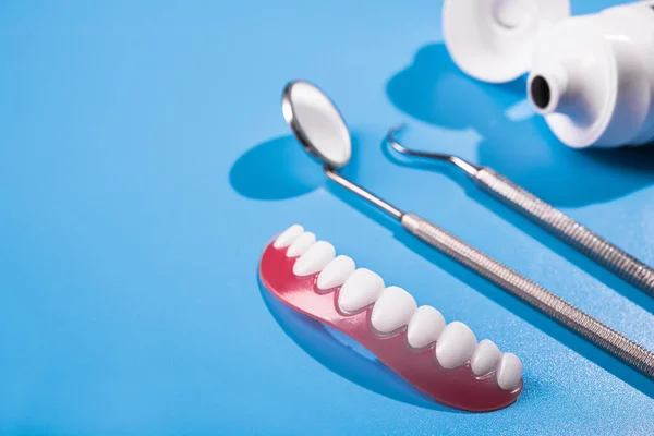 Model Zęba Narzędziem Dentystycznym Niebieskim Stole Klinice Opieka Stomatologiczna Leczenie — Zdjęcie stockowe