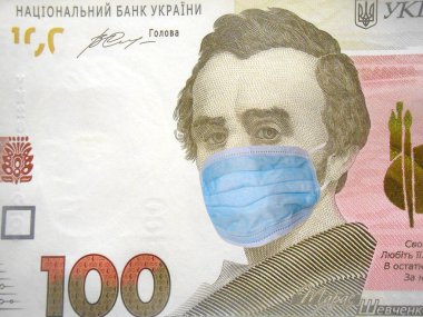 Ukrayna 'da Coronavirus COVID-19. Yüz tane Ukrayna parası, yüz maskeli Hryvnia para faturası. Dünya ekonomisi Corona virüsü salgını ve salgın korkularıyla sarsıldı. Coronavirus küresel borsayı etkiler. Maliye ve kriz kavramı.