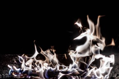 Ateşin alevi karanlıkta yanar.