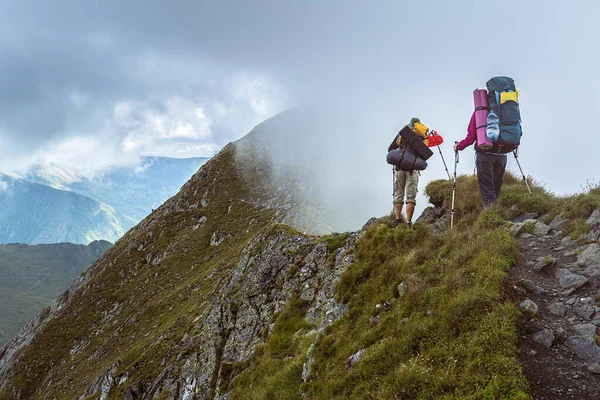 Hikers goes along a steep mountain ridge, Romanian Carpathians, Fagerash array — Stock Photo, Image