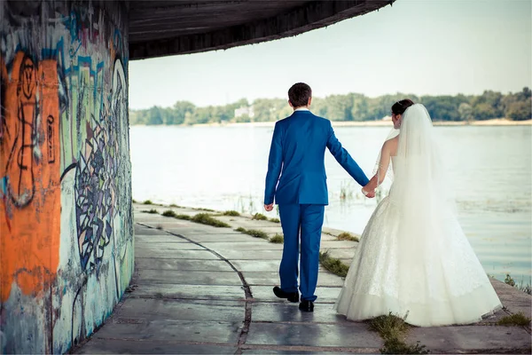 婚礼走在码头上，墙上涂鸦 — 图库照片