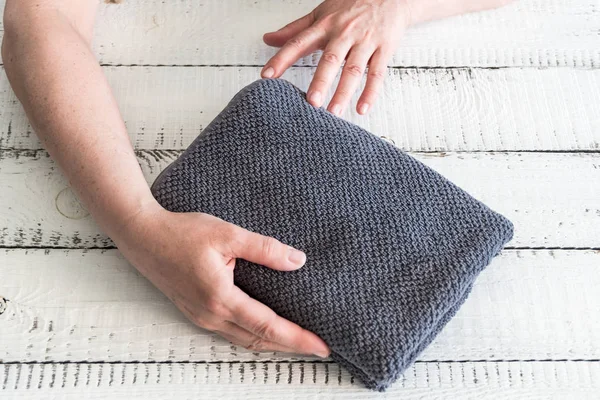 Mulheres dobrando uma toalha cinza para colocá-lo na prateleira. Spa e bem-estar, algodão têxtil terry . — Fotografia de Stock