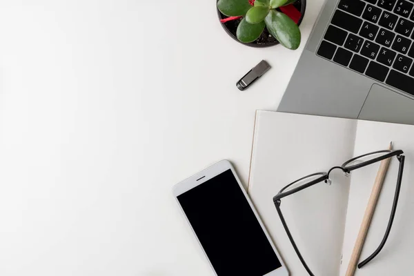 Vista superior del lugar de trabajo de la oficina. Escritorio blanco con espacio para copias. Vista plana en la mesa con ordenador portátil, teléfono, flor, unidad flash y lápiz. Concepto de diseñador creativo . — Foto de Stock