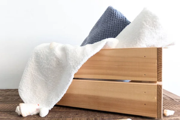 Dobrado diferentes toalhas de banho em caixa de madeira na mesa de madeira marrom. Spa e bem-estar, algodão têxtil terry . — Fotografia de Stock