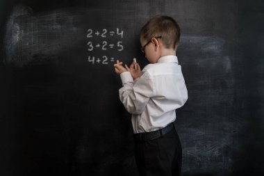 Genç çocuk ilköğretim matematik ifade çözme'nın. Geri okul kavramı. Okul öncesi çocuk akıllı ve zeki
