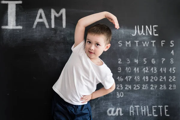 Genç erkek blackboard yakınındaki atletik exersices yapıyor. Genç atlet. Yaratıcı tasarım konsepti 2019 takvim için. Haziran