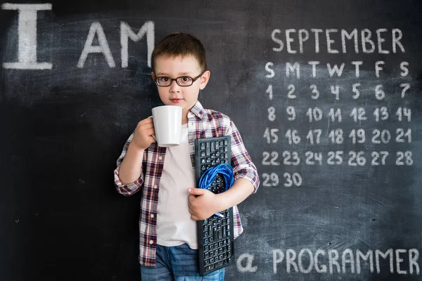 Young boys standing with keyboard and network wire near blackboard. Young programmer or system administrator. Creative design concept for 2019 calendar. September