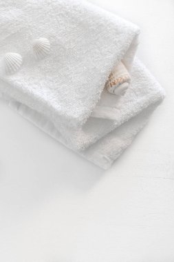Bir beyaz tahta masada iki beyaz havlu katlanmış. Spa ve sağlıklı yaşam, pamuk terry Tekstil. Ekolojik Tema.
