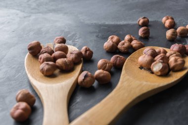 Fındık ile iki ahşap spoones yığınları yan tarafındaki mavi arka plan yerleştirilir. Sağlık ve wellness yaratıcı kavramı. Fındık. Yan görünüm.
