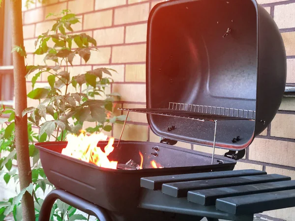 Açılan ızgara yakınındaki kır evi içinde kömür yanma ile. Çiğ et pişirmek hazır. Barbekü yaz açık havada etkinliği.