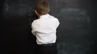 Genç çocuk matematik ifade bir kara tahta üzerinde çözme. Geri okul ve çalışma için yaratıcı kavramı. Okul öncesi