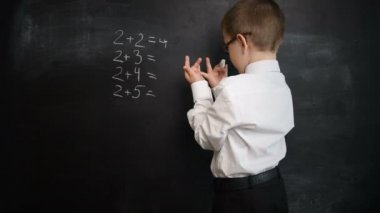 Genç çocuk matematik ifade bir kara tahta üzerinde çözme. Geri okul ve çalışma için yaratıcı kavramı. Okul öncesi