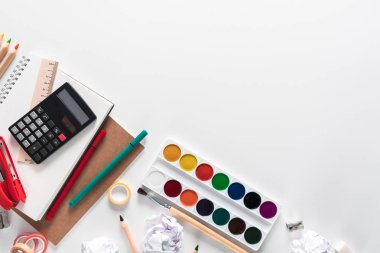 En iyi görünümü üzerinde bir dizüstü bilgisayarlar, boyalar, kalemler, cetveller, ataç, iğne, hesap makinesi, tutkal, kalemtıraş, kalem, kağıt üzerinde beyaz bir arka plan. Okula geri düz Kırtasiye kavramı yatıyordu