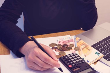 Bütçe planya kavramı. Alışveriş ve tasarruf için bir plan oluşturmak için onun bütçe için masraflar kategorilerini yazma bir kadın yan görünüm. Aile bütçesi kavramı. Gelir ve expence. Kopya alanı.