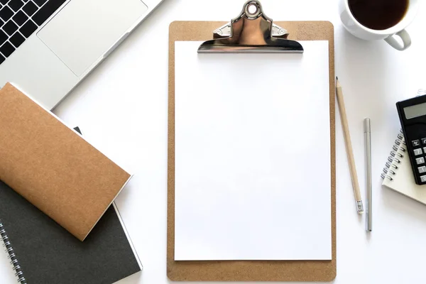 Üstten görünüm defter, kalem, kağıt, dizüstü fincan kahve ve hesap makinesi ile çalışma masası üzerinde. Metin için yer kopyalayın. Düz beyaz arka plan üzerinde bir çalışma alanı'nın yatıyordu.