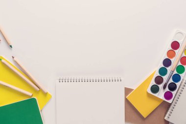 En iyi görünümü üzerinde bir dizüstü bilgisayarlar, boyalar, kalemler, cetveller, ataç, iğne, hesap makinesi, tutkal, kalemtıraş, kalem, kağıt üzerinde beyaz bir arka plan. Okula geri düz Kırtasiye kavramı yatıyordu