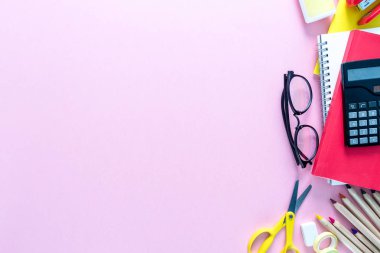 Defter, kalem, kurşun kalem, ataç, Gözlük, hesap makinesi ve vb sağ tarafta pembe bir arka plan olarak bir okul üzerinde en iyi görünümü sağlar. Geri okul kavramı. Ofis malzemeleri düz yatıyordu.