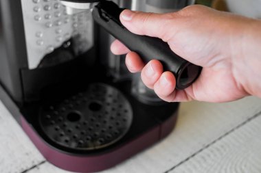 Bir sabah espresso yapmak için bir grup kafa içinde bir kahve makinesi yerleştirerek kadın. Kahvaltı ve ev ekipman kavramı