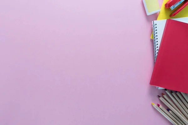 Defter, kalem, kurşun kalem, ataç, zımba ve vb sağ tarafta pembe bir arka plan olarak bir okul üzerinde en iyi görünümü sağlar. Geri okul kavramı. Ofis malzemeleri düz yatıyordu.