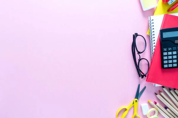 Defter, kalem, kurşun kalem, ataç, Gözlük, hesap makinesi ve vb sağ tarafta pembe bir arka plan olarak bir okul üzerinde en iyi görünümü sağlar. Geri okul kavramı. Ofis malzemeleri düz yatıyordu.