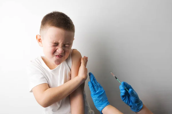 若い男の子は Stop Jestuge で彼の手を置く医療注入を行うを望んでいません 怖い場合予防接種 少年と青の手袋で彼の手に注射器で医師 Preventional 予防接種予防接種の概念 — ストック写真
