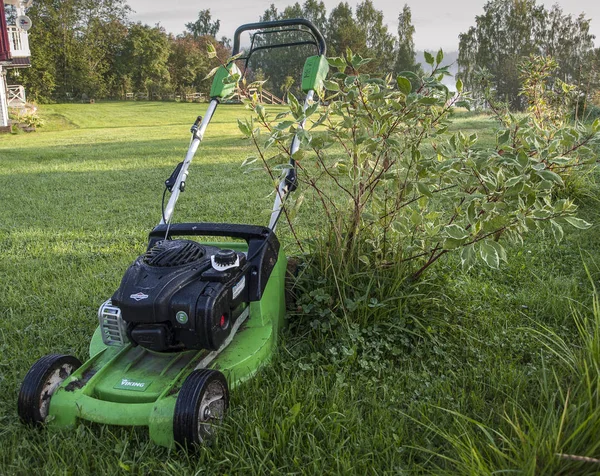 bir kır evinin çim üzerinde sabah çiy çim biçme makinesi