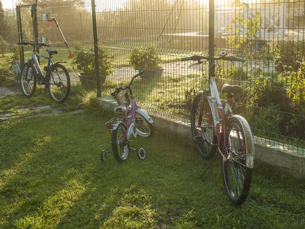 Bir kır evinin çitinde çocuklar tarafından bırakılan bisikletler. Sisli eylül sabahı